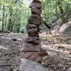 Mehrere flache Steine zu einem Turm gestapelt - im Wald