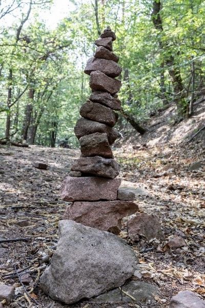 Mehrere flache Steine zu einem Turm gestapelt - im Wald
