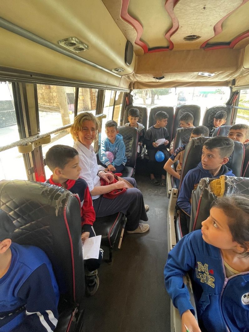 Kinder und Mitarbeiterinnen von Pro Terra Sancta im "Bus des Lebens" in Aleppo im April 2024.